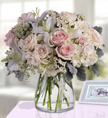 3 stems of White Lilies , 10 Stem of Peach Roses , White Hydrangeas & Fillers in a Glass Vase (one sided Round arrangement) Flourish