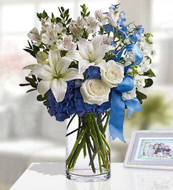 1 stem of White lilies ,6 stem of White Rose, 3 stems of White Astromeria, Blue Hydrangea & blue ribbons in a Glass vase (one sided Round arrangement) Blissful Bouquet