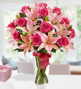 6 stems of Pink Lily and 14 stems of Pink Rose in a glass Glass vase. (one sided round arrangement) Magnificent