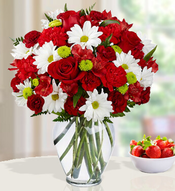 5 stems of red Roses ,3 stems of white and 2 stems of green chrysanthemums ,6 stems of Red carnations and greens in a Glass vase (one sided round arrangement) Simply Irresistible