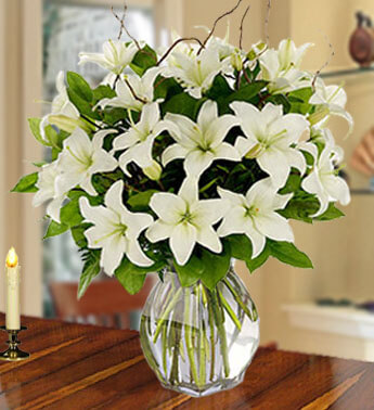 Arrangements of 8 stems of White Lilies with fillers in a glass vase. Stunning Purity