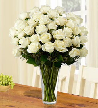36 White Roses with fillers in a glass vase. Faithful Blessings