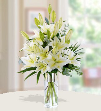 6 stems of white Lilies with fillers in a glass Vase. Stunning White