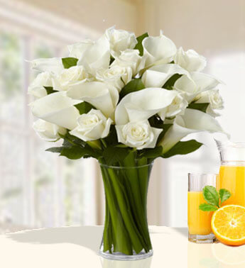 12 stems of White Roses and 10 white Calla Lilies in a glass vase. Divinely Gift