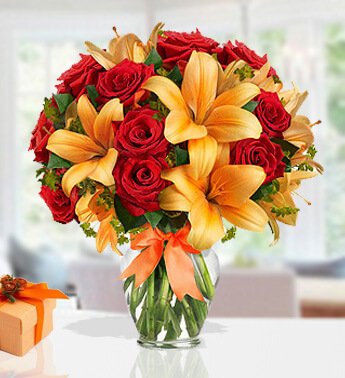 12 Red Roses and 4 stems of Orange Lilies in a Glass vase (one sided Round arrangement) Splendid Bouquet