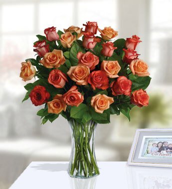 24 Orange Roses with fillers in a glass vase. The Sun