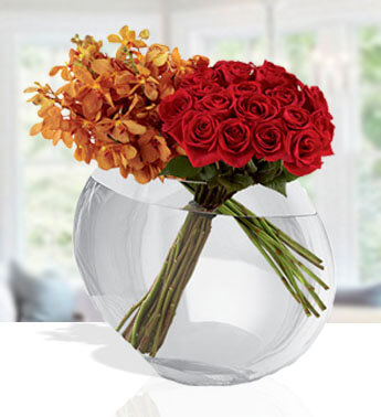 18 Red Roses and 10 Orchids Mokara orchids and a clear glass pillow vase. Sophisticated Orange