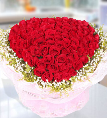 Heart Shape arrangement of 100 Red Roses with fillers with Net packing. Pure Heart