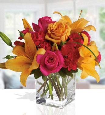 Arrangement of 1 Stem of Orange and 1 Stem of Yellow Lilies, 3 pink roses, 1 Orange rose,4 Red carnations and greenery in a Glass Vase (one sided round arrangement) Special Chic